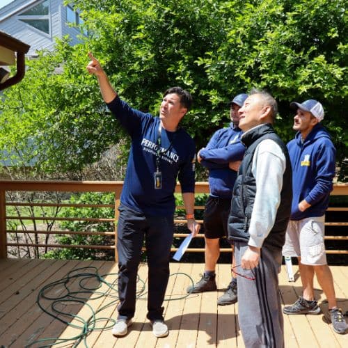 Crew with homeowner inspecting roof by Performance Roofing and Siding